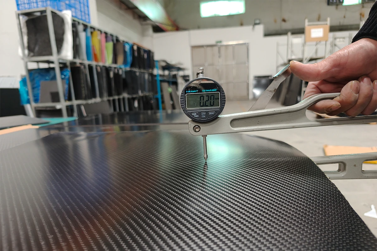 Engineer measuring carbon fiber sheet thickness
