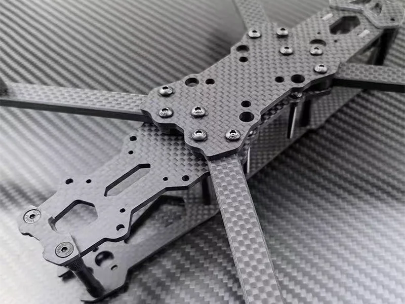carbon fiber drone frame close-up showing weave pattern and CNC cut edges