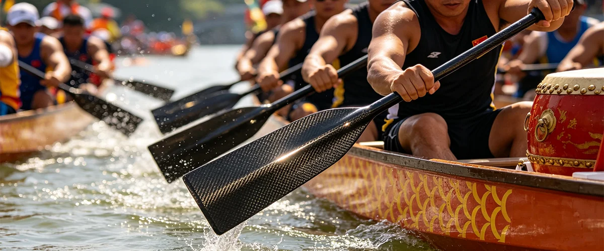 carbon fiber paddles entering water in synchronization during dragon boat race with splash pattern