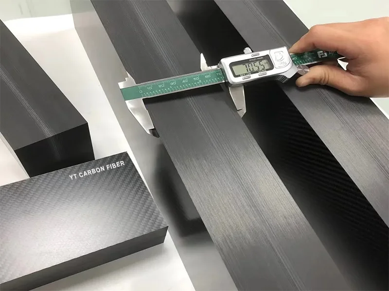 Extra thick carbon fiber plate being CNC machined into precision industrial parts