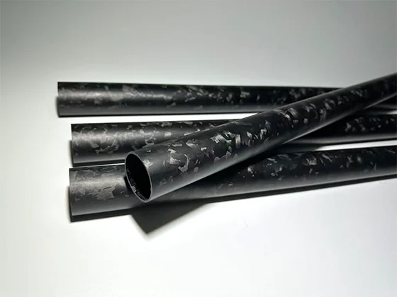 Close-up of forged carbon fiber marbled surface texture showing random fiber pattern