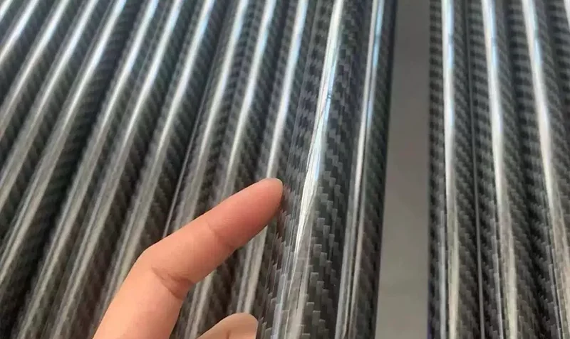 Over 4500 round glossy twill carbon fiber tubes arranged on factory workshop floor awaiting quality inspection