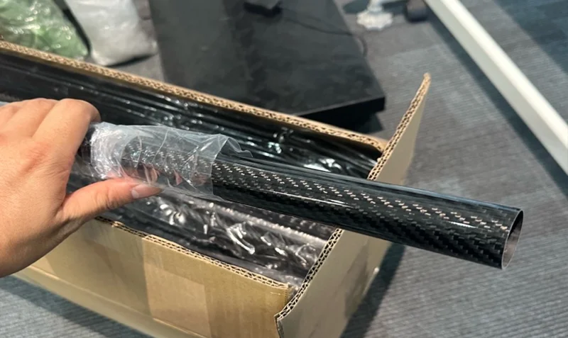 Packed glossy twill carbon fiber tubes on wooden pallets loaded into shipping container at YTCarbon facility
