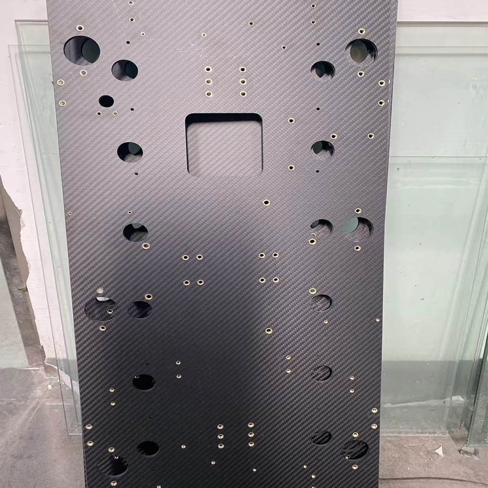 Close-up of threaded insert embedded in carbon fiber plate, stainless steel helicoil with internal thread detail