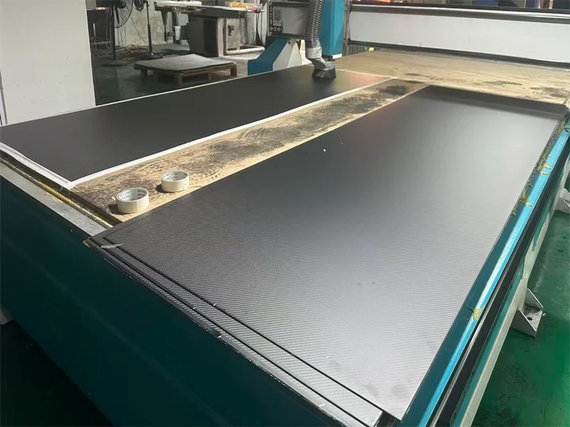 CNC machining of large format carbon fiber sheet in China factory showing cutting and drilling