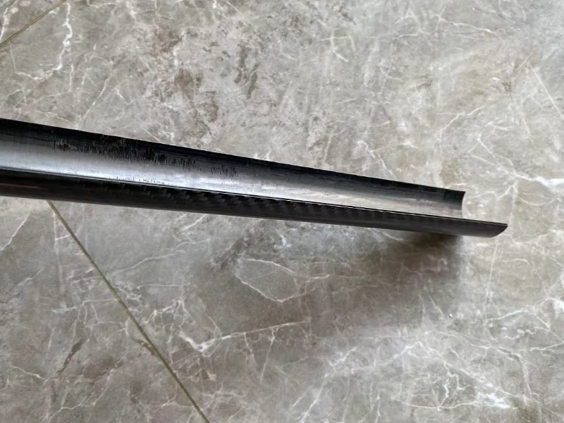 Precision cut half-round carbon fiber tube profile showing clean cross-section and glossy surface for architectural decoration